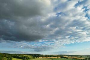 Most Beautiful High Angle view of Dramatical Sky and Clouds over British Countryside Landscape During Sunset photo