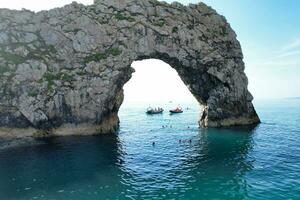 Best Aerial Footage of People are Enjoying Boat Ride at Gorgeous British Tourist Attraction and Ocean Sea View of Durdle Door Beach of England UK. Captured with Drone's Camera on September 9th, 2023 photo