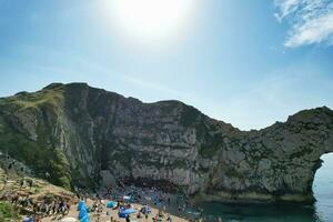 mejor aéreo imágenes de personas son disfrutando barco paseo a maravilloso británico turista atracción y Oceano mar ver de durdle puerta playa de Inglaterra Reino Unido. capturado con drones cámara en septiembre 9, 2023 foto