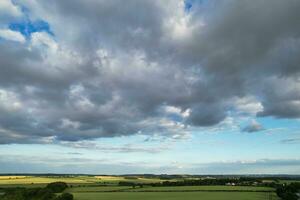 Most Beautiful High Angle view of Dramatical Sky and Clouds over British Countryside Landscape During Sunset photo