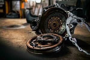 Gearbox, clutch and flywheel on the floor in the garage indergoing repar. photo