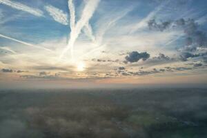 Most Beautiful and Best High Angle Dramatical Colourful Sky Footage from Above The Clouds. The Fast Moving Clouds During Sun rising Early in the Morning over Luton City of England UK photo