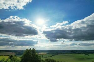 Most Beautiful High Angle view of Dramatical Sky and Clouds over British Countryside Landscape During Sunset photo