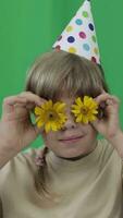 a young girl wearing a party hat and holding flowers video