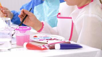 two children are painting at a table video