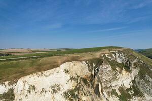 High Angle View of People are Approaching to Durdle Door Beach Which is Most Famous Tourist Attraction Place Through Walking Distance over Landscape and Hills. Captured on September 9th, 2023 photo