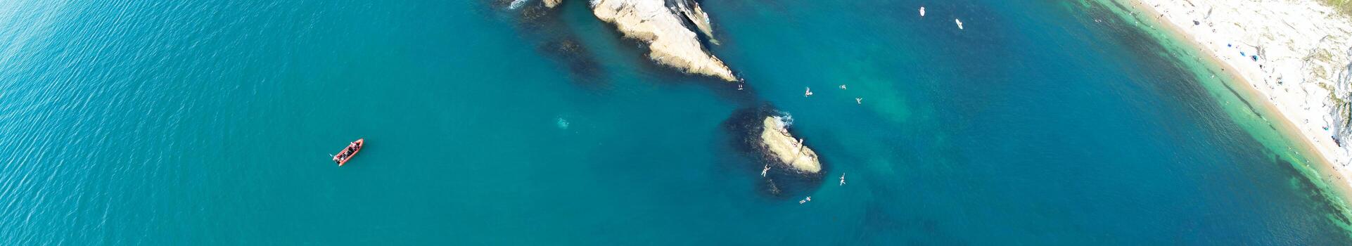 People at Most Beautiful High Angle View of British Landscape and Sea View of Durdle Door Beach of England Great Britain, UK. Image Was captured with Drone's camera on September 9th, 2023 photo