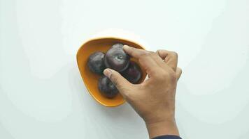 main choisir Frais prunes dans une bol sur table video