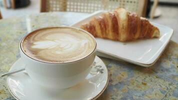 caffè e croissant sul tavolo di legno, vista dall'alto. video