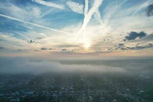 Most Beautiful and Best High Angle Dramatical Colourful Sky Footage from Above The Clouds. The Fast Moving Clouds During Sun rising Early in the Morning over Luton City of England UK photo