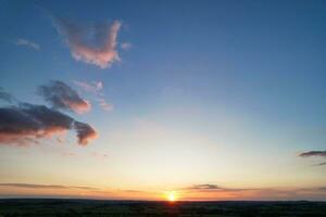 Most Beautiful High Angle view of Dramatical Sky and Clouds over British Countryside Landscape During Sunset photo