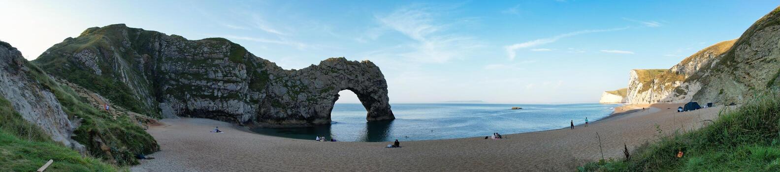 People at Most Beautiful High Angle View of British Landscape and Sea View of Durdle Door Beach of England Great Britain, UK. Image Was captured with Drone's camera on September 9th, 2023 photo