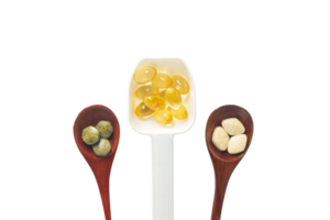 Top view variety of vitamins, minerals, and fish oil in pill form on a wooden spoon isolated on a white or transparent background. Dietary food supplements are a new alternative to health care. png