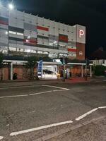 Low Angle View of Illuminated Road and Car Park Building Opposite of Luton and Dunstable Hospital at Luton City of England UK During night of Sep 3rd, 2023. photo