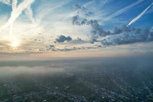 Most Beautiful and Best High Angle Dramatical Colourful Sky Footage from Above The Clouds. The Fast Moving Clouds During Sun rising Early in the Morning over Luton City of England UK photo