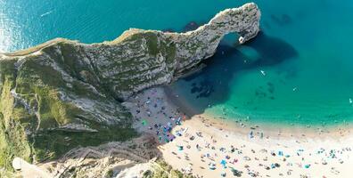 People at Most Beautiful High Angle View of British Landscape and Sea View of Durdle Door Beach of England Great Britain, UK. Image Was captured with Drone's camera on September 9th, 2023 photo