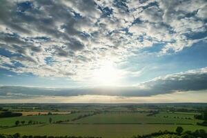 Most Beautiful High Angle view of Dramatical Sky and Clouds over British Countryside Landscape During Sunset photo