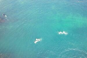 People at Most Beautiful High Angle View of British Landscape and Sea View of Durdle Door Beach of England Great Britain, UK. Image Was captured with Drone's camera on September 9th, 2023 photo