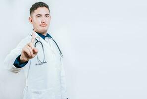 Doctor counting number ONE isolated. Handsome doctor counting number 1 on isolated background. Young doctor raising index finger isolated photo