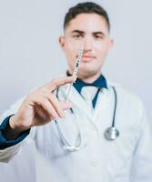 Caucasian doctor holding a syringe on isolated background. Closeup of doctor holding and showing a syringe isolated photo