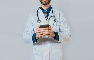 Doctor hands holding paper coffee. Doctor holding takeaway coffee on isolated background, Young doctor holding a coffee to go isolated photo