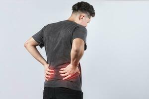 Man with spine problems, person with back problems on isolated background, lumbar problems concept, a sore man with back pain photo