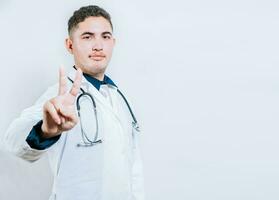 Latin doctor counting number two isolated. Smiling young doctor counting number 2 on isolated background. photo