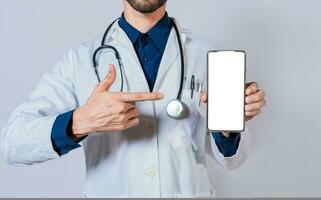 médico demostración y señalando a blanco célula teléfono pantalla. médico recomendando en célula teléfono pantalla aislado foto