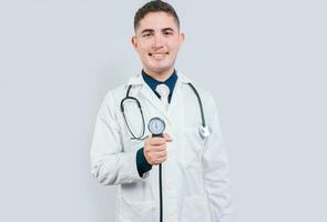 Cheerful doctor holding blood pressure monitor. Young doctor showing blood pressure monitor isolated photo