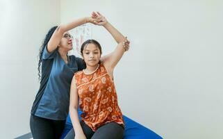 Young physiotherapist with patient rehabilitating shoulder and elbow, Physiotherapist with female patient rehabilitating elbow. elbow and shoulder rehabilitation physiotherapy photo