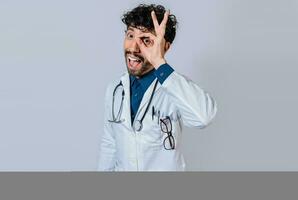 Handsome doctor approving and recommending isolated. Happy doctor gesturing approval isolated, Latin doctor approving on isolated background photo