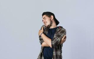 Friendly man hugging himself, Pleased young man hugging himself, Attractive positive looking friendly young man with a sincere smile embracing himself gratefully photo