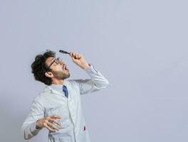 Surprised man in lab coat with magnifying glass looking at an advertisement above. Scientist man looking up with a magnifying glass. Amazed man observing an advertisement with a magnifying glass photo