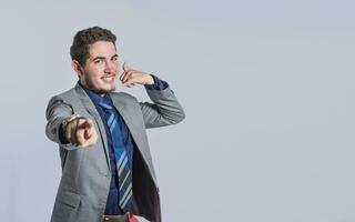 Man making phone gesture with his fingers, Hispanic young man making phone gesture and pointing to the front, a signal of a man calling photo