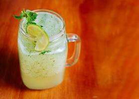 Refreshing lemonade with mint on wooden table. Lemonade drink on wooden table photo