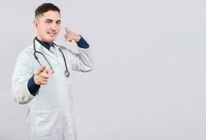 hermoso médico haciendo llamada gesto aislado. sonriente médico haciendo llamada gesto y señalando a el cámara. foto