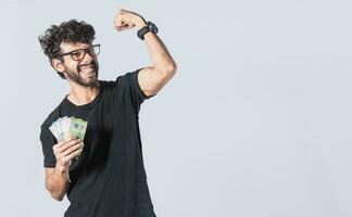 Happy man with money raising his fist, joyful man with bills in hand, concept of man with money isolated photo