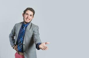 Man extending his hand inviting, man in suit welcoming, man looking at camera presenting a product, person inviting photo