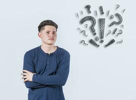 Thoughtful young man looking up with exclamation marks, Thoughtful man with exclamation marks on isolated background, Indecisive man looking up , Concept of man asking with exclamation marks photo