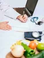 Hands of male nutritionist taking notes at his desk, Nutritionist hands taking medical records in the office. Close-up of nutritionist writing on notepad photo