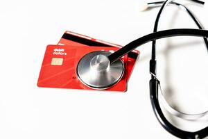 Stethoscope on isolated credit card. Online healthcare payment concept, A stethoscope on credit cards on white background photo