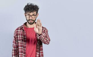 Portrait of handsome man making stop gesture with his palm. Serious man making stop sign with his palm. concept of person doing stop on isolated white background photo