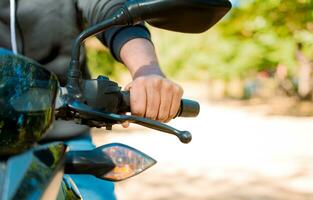 Close up of the hands on the handlebars of a motorcycle. Hands of a person on the motorcycle handlebars. Motorbike speeding concept, Hands of a motorcyclist on the handlebars photo