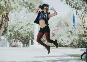 Happy urban girl jumping and listening to music, Girl jumping in the street and listening to music, Lifestyle girl listening to music, Woman jumping and enjoying music photo