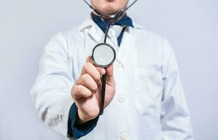 Close up of doctor showing stethoscope medical isolated. Unrecognizable doctor holding a stethoscope photo