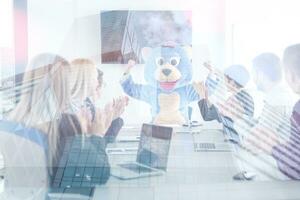 boss dresed as bear having fun with business people in trendy office photo