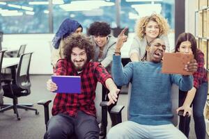 multiethnics business team racing on office chairs photo