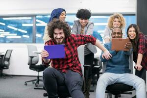 multiethnics business team racing on office chairs photo