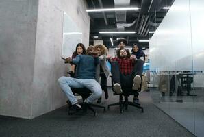 multiethnics business team racing on office chairs photo