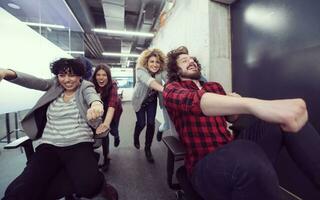 multiethnics business team racing on office chairs photo